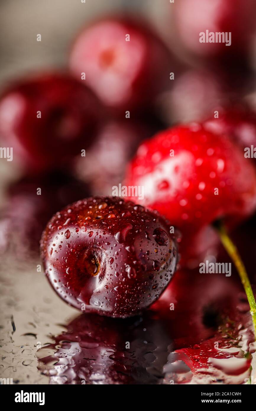 ancora vita di ciliegie rosse e succose su sfondo scuro. Gruppo di ciliegie. Foto Stock