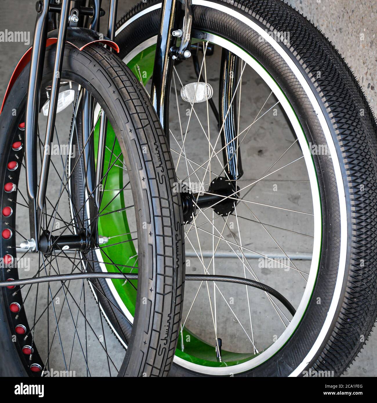 Due biciclette con pneumatici grasse chiuse insieme, una rossa e una blu, sul marciapiede vicino alla spiaggia di Santa Barbara, California Foto Stock