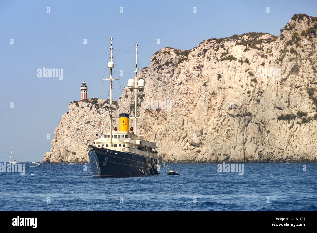 ISOLA DI CAPRI - AGOSTO 2019: Superyacht di lusso all'ancora vicino al faro di Punta Carena sull'Isola di Capri. Foto Stock