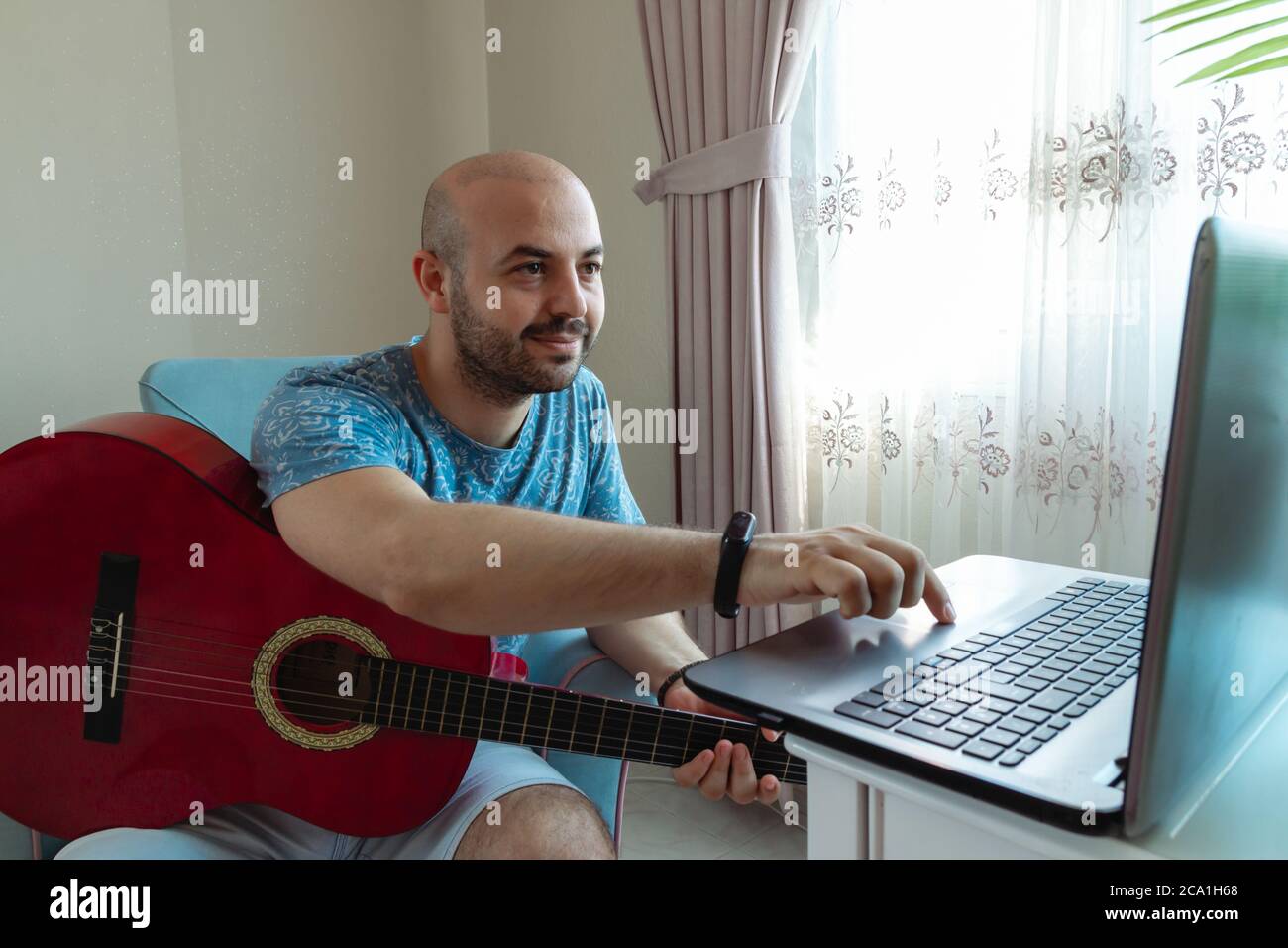 adolescente con una chitarra imparare a suonare uno strumento musicale su internet, turchia Foto Stock