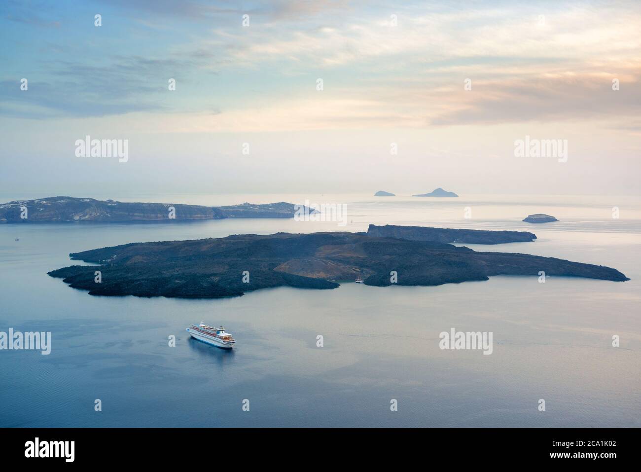Piccole isole vulcaniche in mare, nave da crociera. Santorini, Grecia Foto Stock