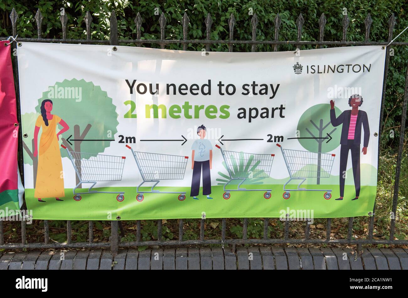Banner di divaricamento sociale a Islington Park che dice che devi stare a due metri di distanza, Highbury Fields, London Borough of Islington Foto Stock