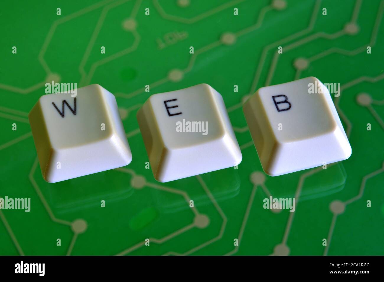 I tasti della tastiera formano la parola web sul verde del circuito elettrico in background. Foto Stock