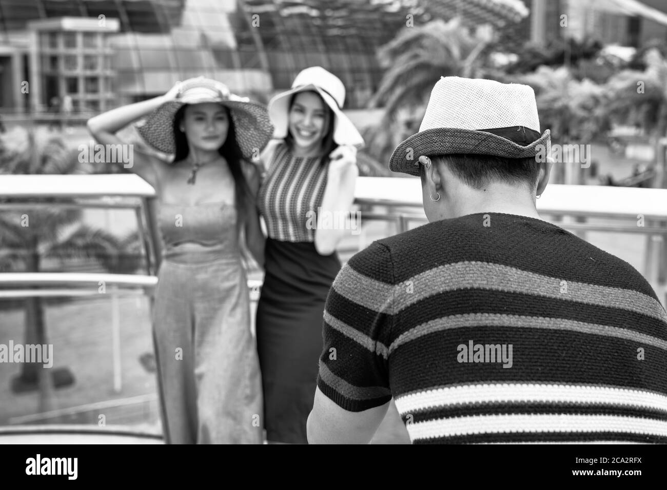 Uomo asiatico che scatta foto di due donne asiatiche. Concetto di viaggio e vacanza. Foto Stock