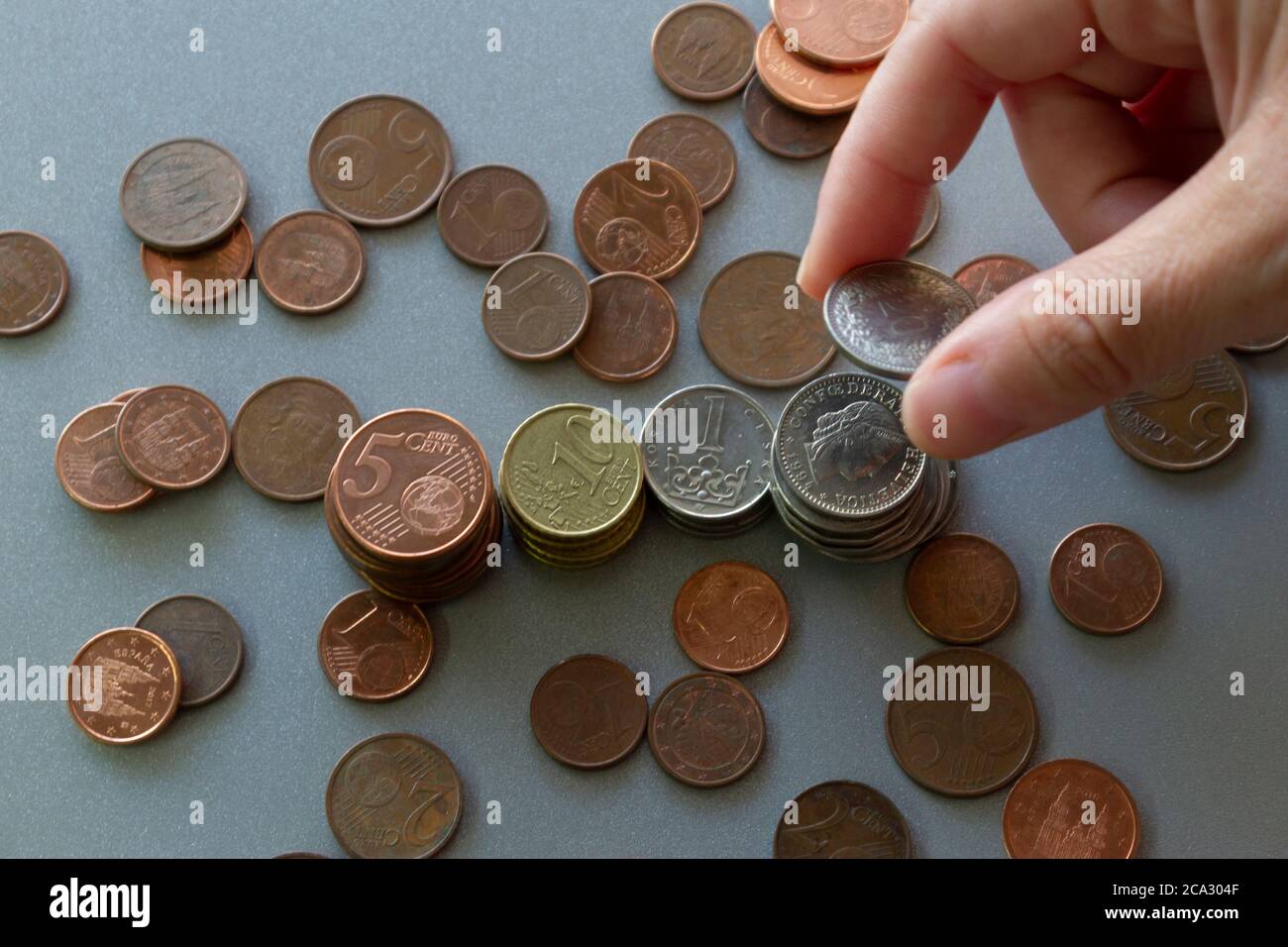 Mano tenendo e disponendo moneta in pila column.Finance e risparmio concept.Top view.Money, finanze e banca concept.Crisis. Foto Stock