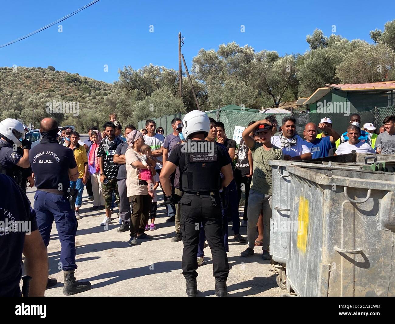 Moria, Grecia. 04 agosto 2020. Durante una visita del primo ministro della Renania Settentrionale-Vestfalia Laschet al campo profughi di Moria, le forze di sicurezza hanno protetto i rifugiati che hanno cantato 'Moria libera'. Laschet (CDU), Ministro Presidente della Renania Settentrionale-Vestfalia, sta visitando il campo profughi di Moria sull'isola di Lesbos come parte di una gita di diversi giorni in Grecia. Credit: Hülsmeier/dpa/Alamy Live News Foto Stock
