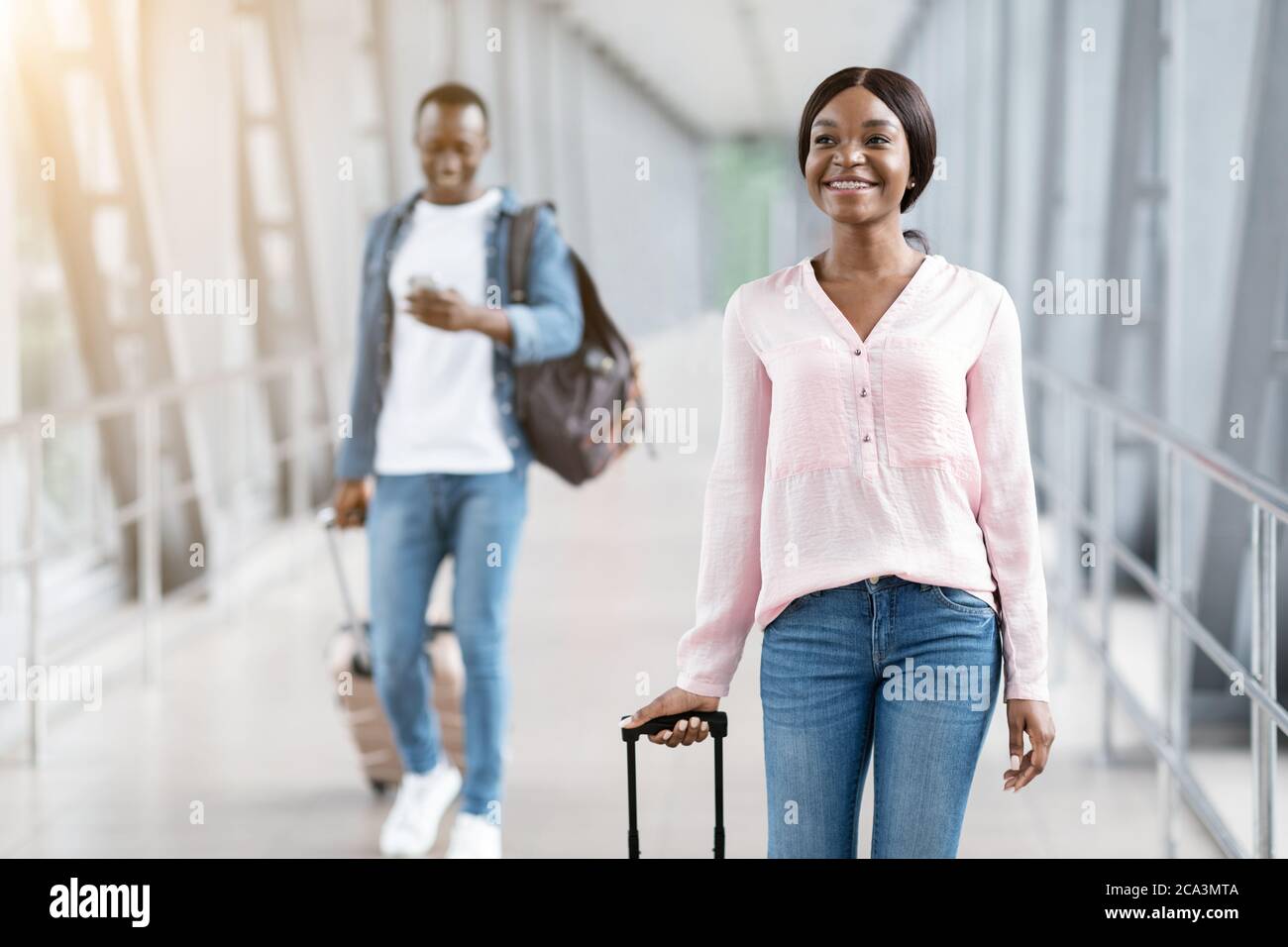 Concetto di viaggio. Happy Man e Woman a piedi al terminal dell'aeroporto con bagagli Foto Stock
