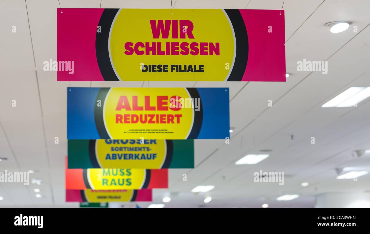 I cartelli all'interno della Galeria Kaufhof a Karlsplatz Stachus informano i clienti che tutto ciò che è in vendita a causa della chiusura permanente della filiale. Foto Stock