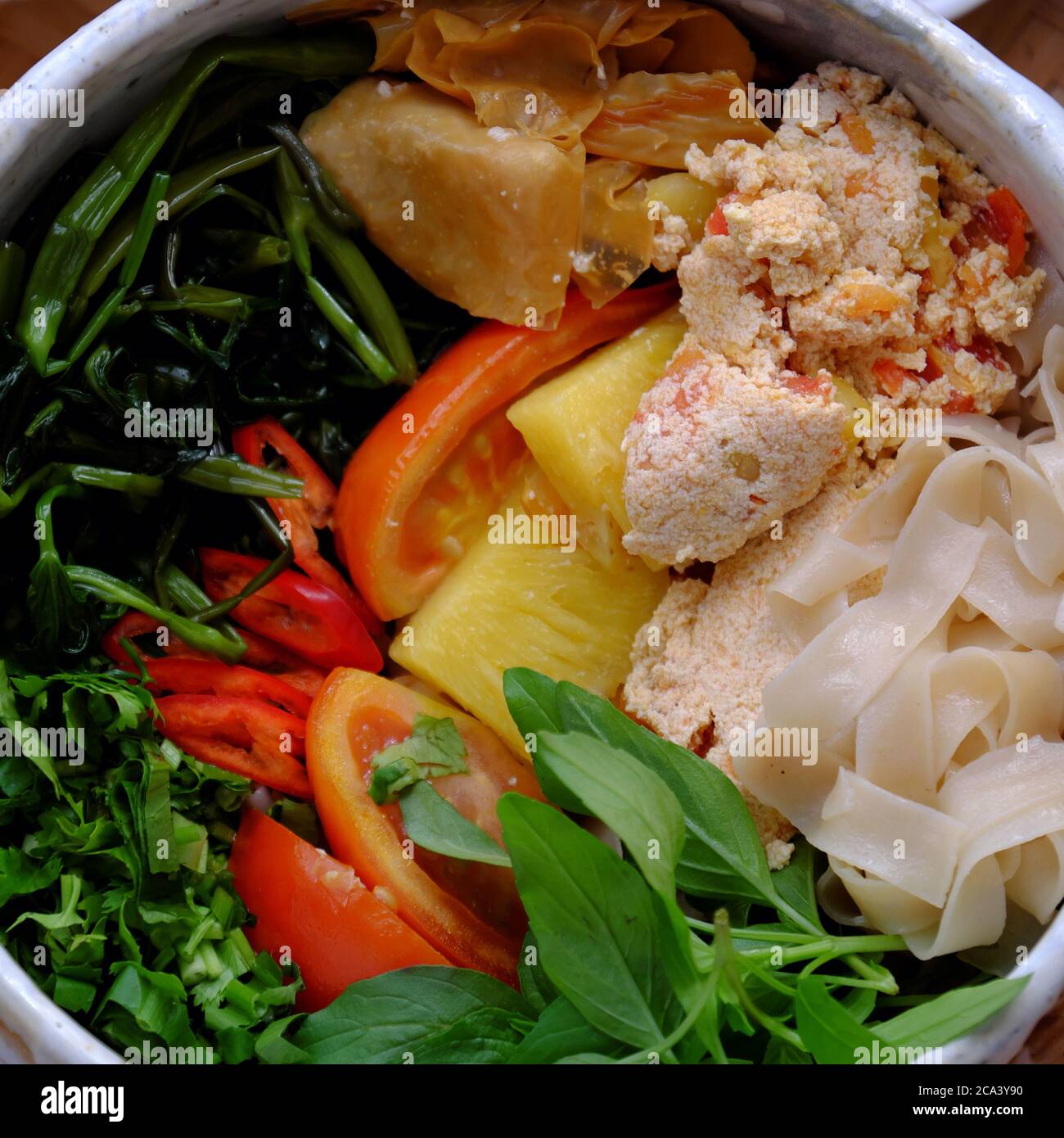 Vista dall'alto primo piano ciotola per zuppa di tagliatelle di carta secca, tofu, ananas, pomodoro, spinaci d'acqua, verdura per la nutrizione vietnamita alimentazione sana per la dieta pasto Foto Stock