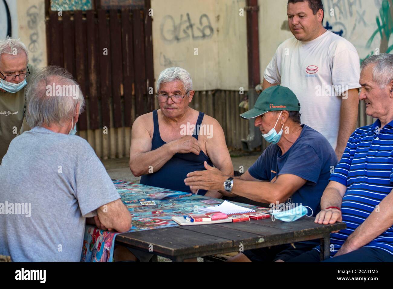 Zrenjanin, Serbia, 29 luglio 2020. I signori più anziani e i pensionati giocano le carte ogni giorno all'ombra di un grande albero. Ci sono sempre osservatori curiosi Foto Stock
