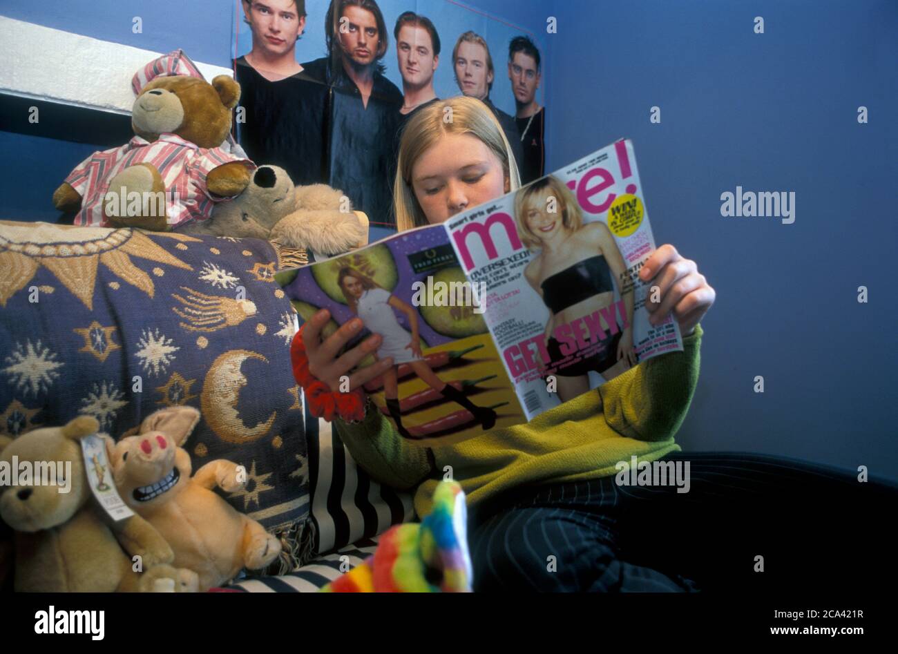 Ragazza adolescente nella sua camera da letto che legge più rivista UK Foto Stock