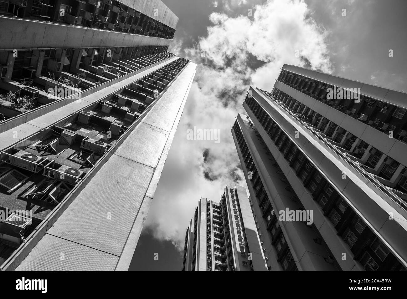 Architettura della città di Hong Kong, alto blocco di appartamenti sono sotto il cielo nuvoloso, foto di sfondo bianco e nero Foto Stock