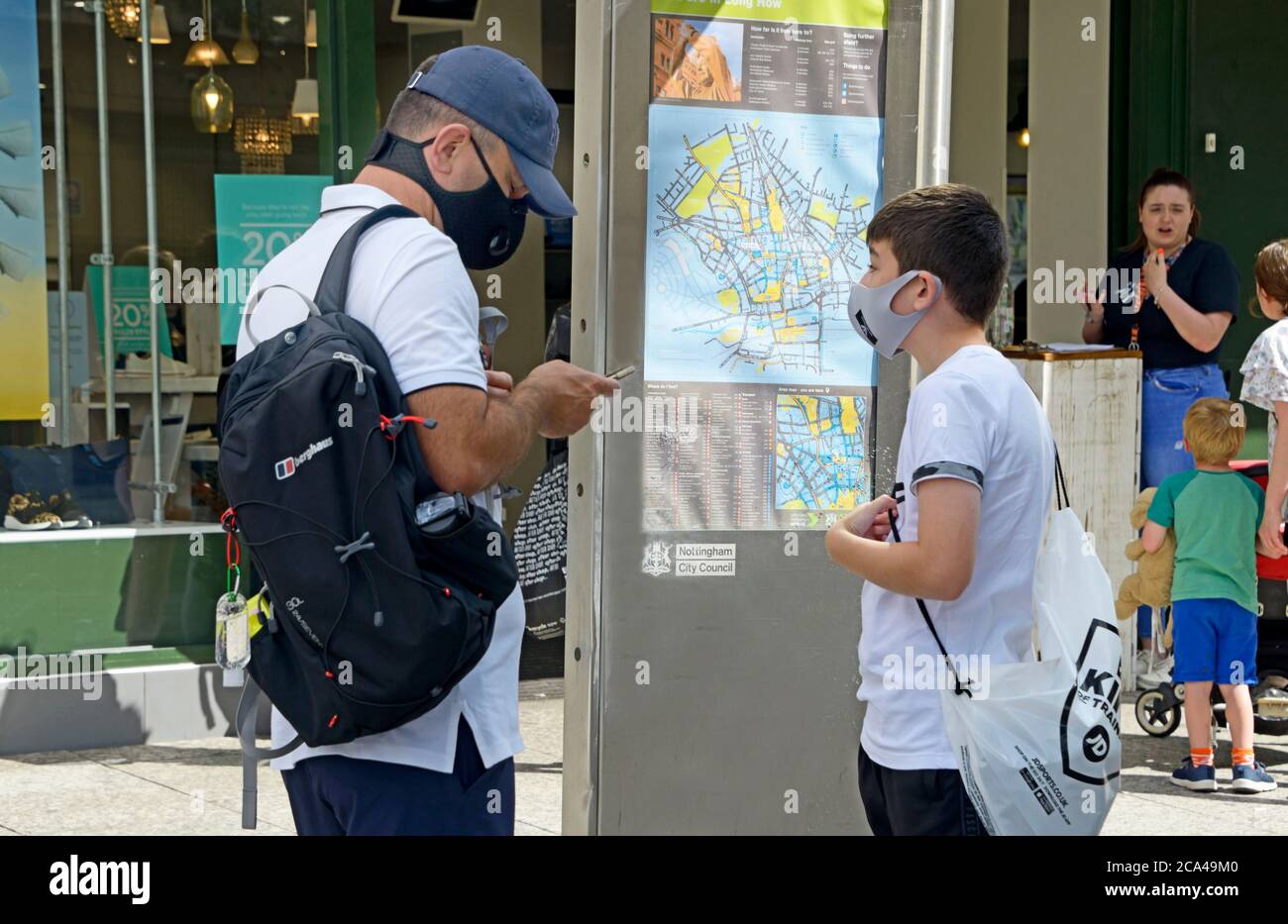 Padre e Figlio, controllare le indicazioni, indossare maschere. Foto Stock