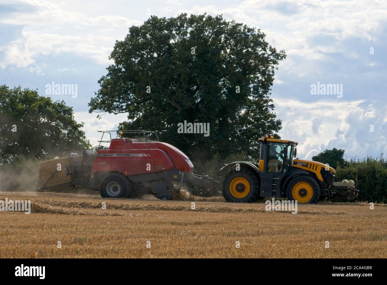 Imballaggio dopo il raccolto Vista ravvicinata dell'espulsione del contenitore Balla sul terreno che si sposta da sinistra a destra ingresso polvere Il formato Air Cloudy Trees Landscape Foto Stock