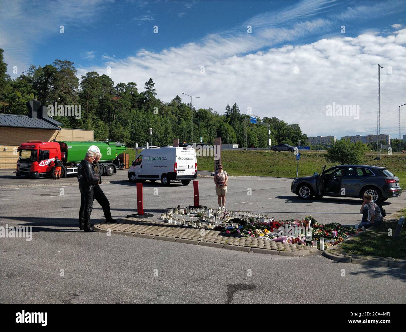 Stoccolma. 4 agosto 2020. La gente locale si riunisce e pianse vicino al sito dove una ragazza di 12 anni è stata uccisa dopo essere stata colpita da un proiettile vagabugnante in una gang sparando in un parcheggio di una stazione di benzina a Norsborg, a sud di Stoccolma, Svezia, 4 agosto 2020. Il ministro svedese degli interni Mikael Damberg ha promesso martedì di affrontare i crimini legati alle bande dopo la recente tragica morte di una ragazza di 12 anni. Secondo la televisione svedese, la sparatoria faceva parte di un crescente conflitto tra bande che combattevano sui mercati locali della droga. Credit: Xinhua/Alamy Live News Foto Stock