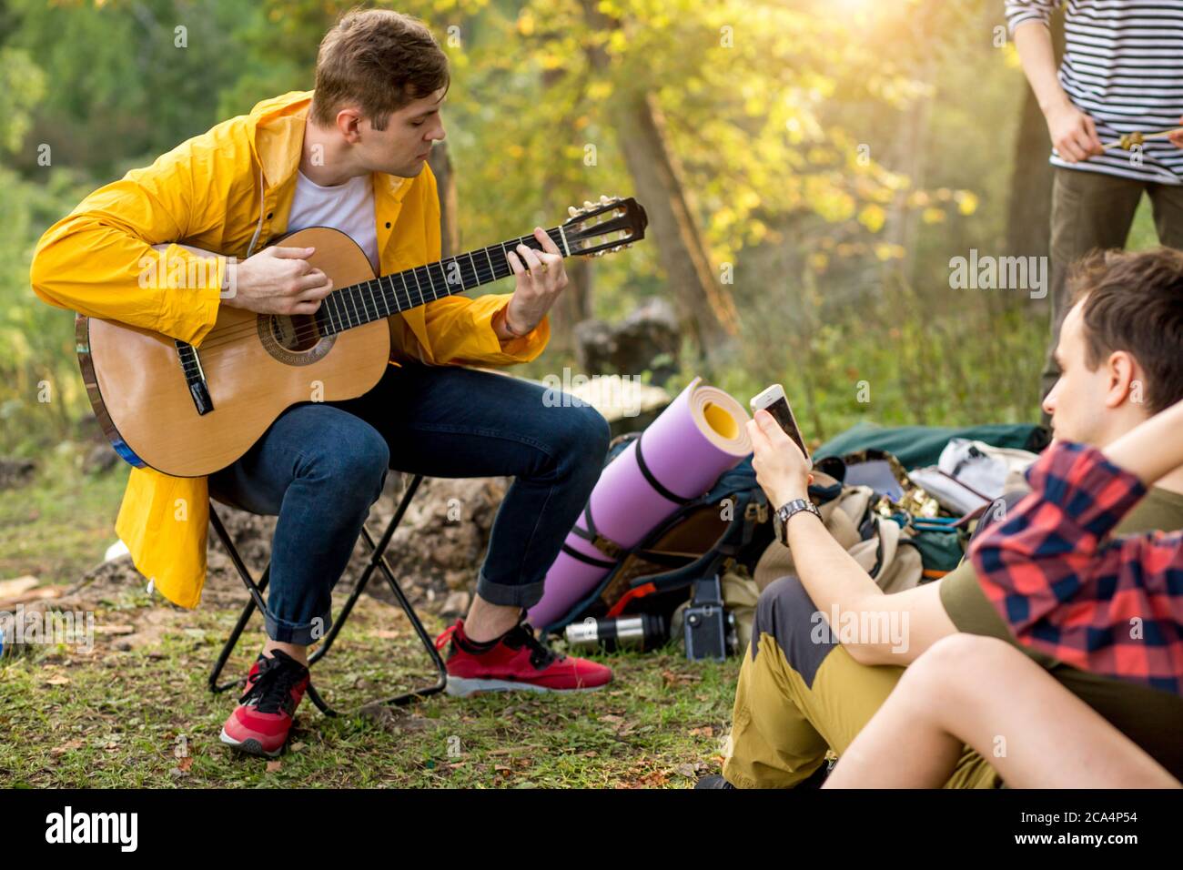 giovane uomo di talento che tiene la chitarra, suonando musica per gli amici primo piano foto Foto Stock