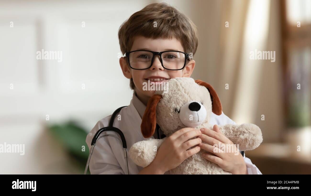 Piccolo bambino carino in giocattolo medico cappotto coccolante. Foto Stock