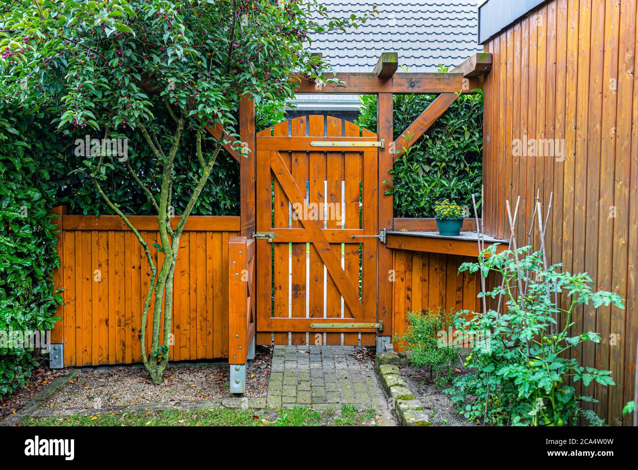 Cancello di legno e la recinzione sul retro del giardino di casa. La porta  è chiusa con un lucchetto Foto stock - Alamy