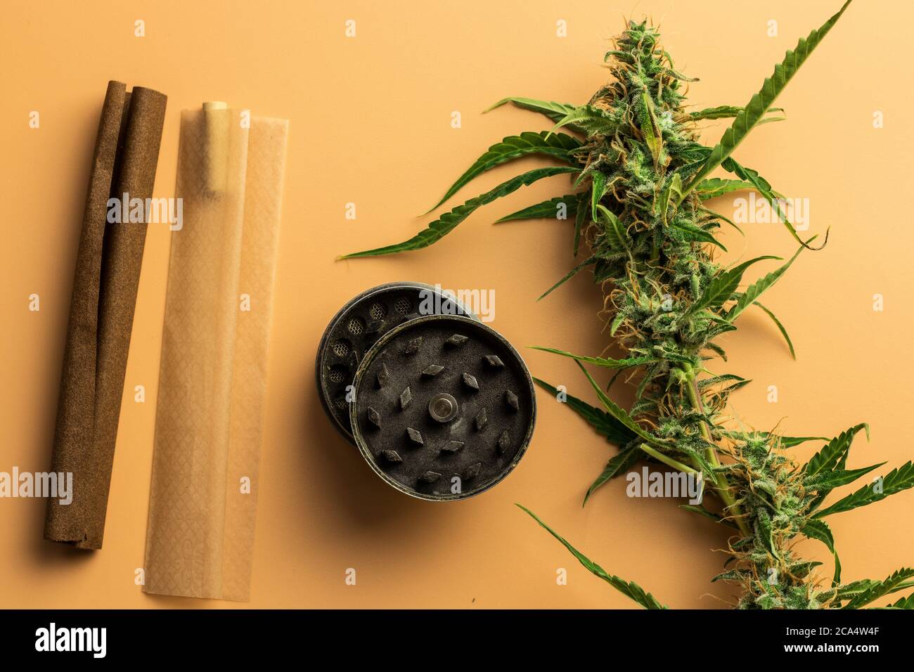 Gli accessori per fumatori di marijuana sono appoggiati sulla scrivania. Smussato, giunto e smerigliatrice. Concetto di uso di cannabis. Carta organica per erbacce Foto Stock