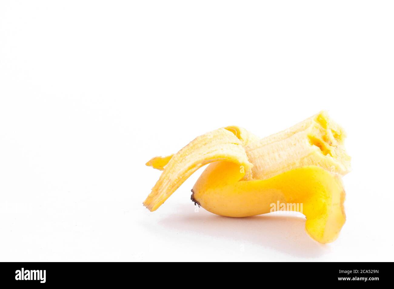 Uovo sbucciato banana con manca un morso su sfondo bianco sano Pisang Mas banana frutta cibo isolato Foto Stock