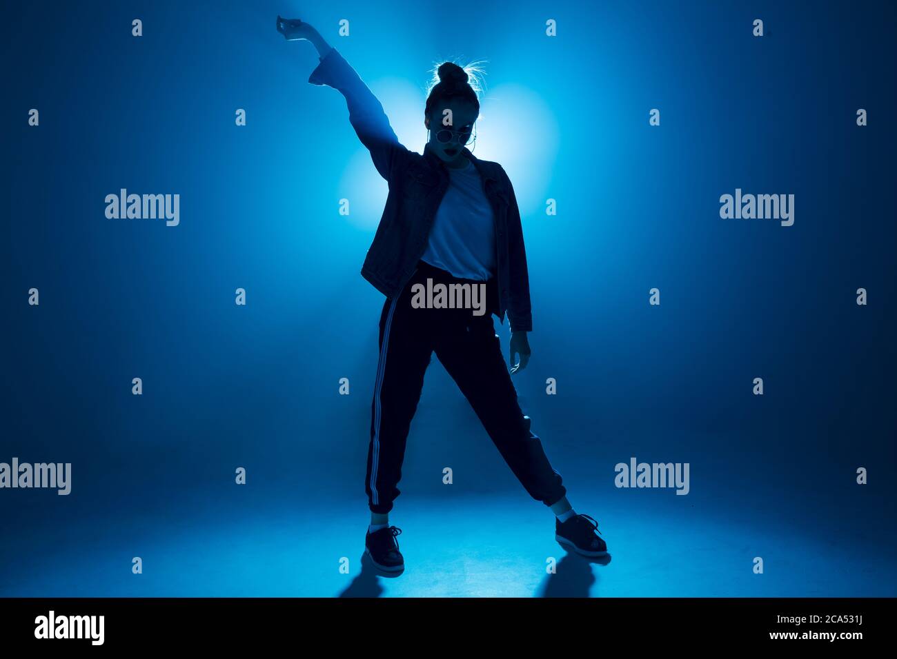 Donna elegante che danzava da sola durante una festa hip hop. Occhiali da  sole, moderno abbigliamento da ballo nero, luci al neon Foto stock - Alamy