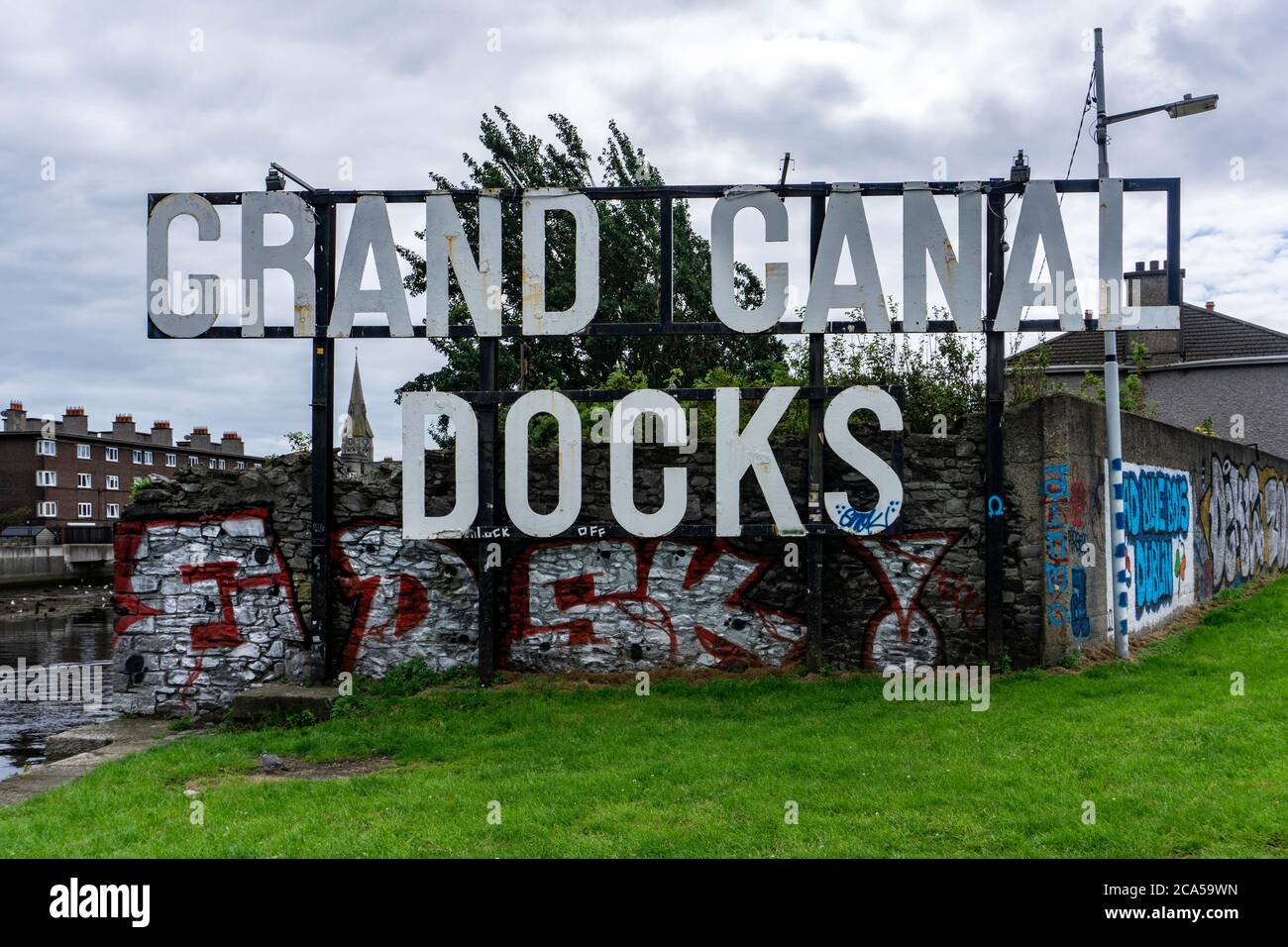Grand Canal Docks. Il vecchio cartello per Grand Canal Docks, Dublino, Irlanda, accoglie le persone in un'area che è cambiata oltre ogni riconoscimento. Foto Stock