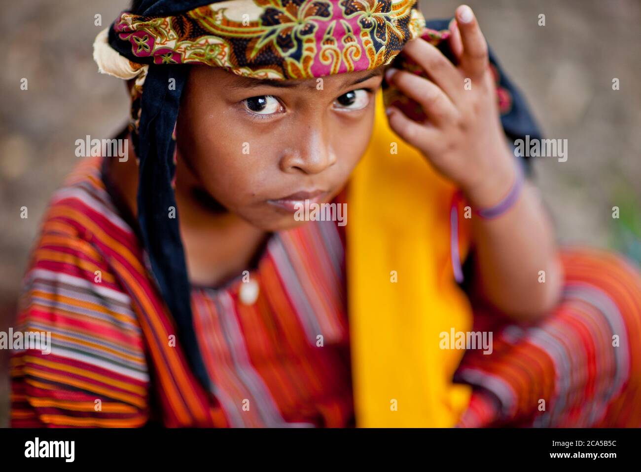 Indonesia, Sulawesi, Tana Toraja, Bori, cerimonia funeraria, ritratto di un giovane con uno sguardo intenso e con abiti tradizionali colorati Foto Stock