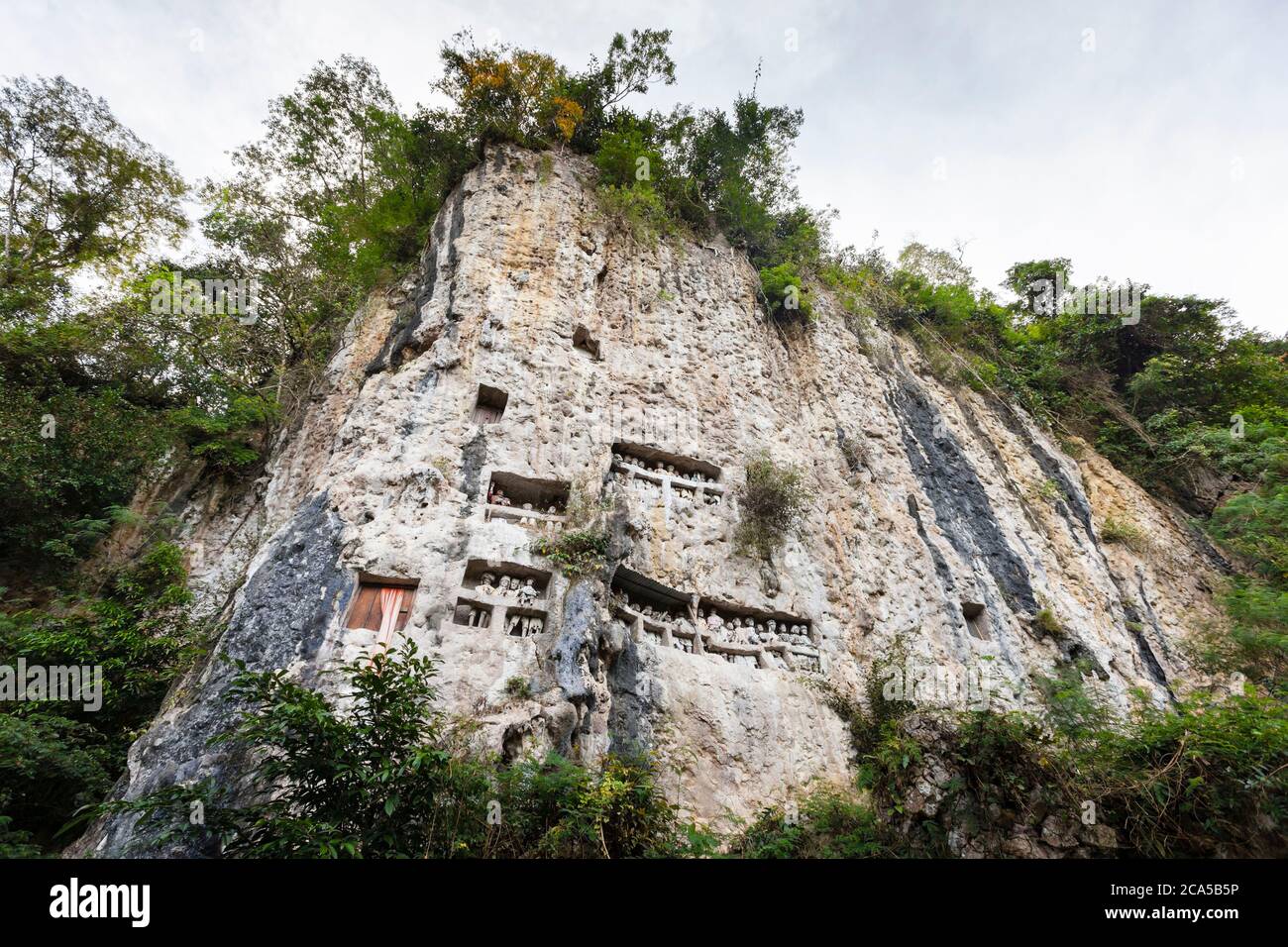 Indonesia, Sulawesi, Tana Toraja, Tampang allo, scogliera mortuaria con tombe scavate nella roccia e presentanti Tau-Tau, statue in legno raffiguranti decea Foto Stock