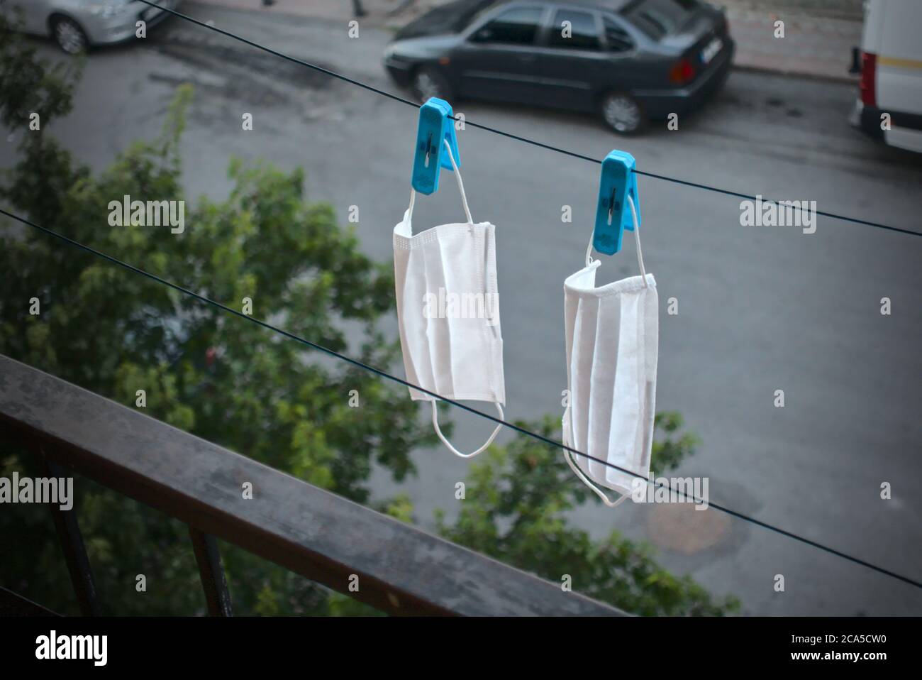 Maschere chirurgiche lavate appesi con pioli sulla corda per asciugare Foto Stock