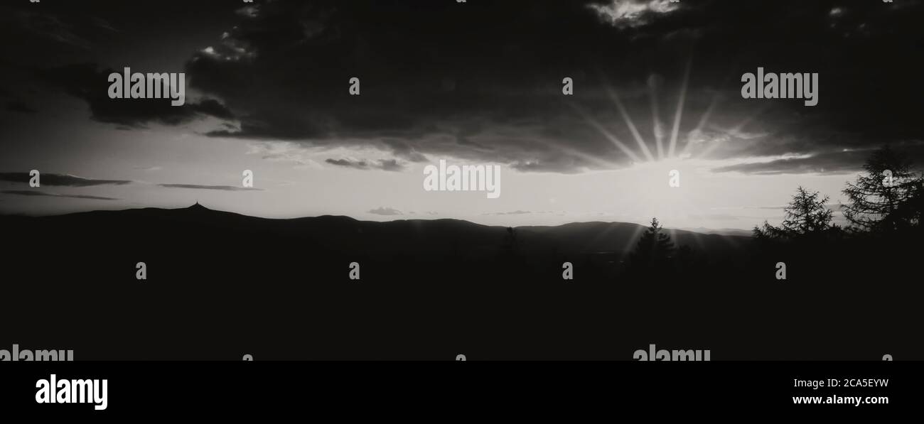Cielo all'alba al tramonto con la silhouette di Jested Ridge, bianco e nero. Foto Stock