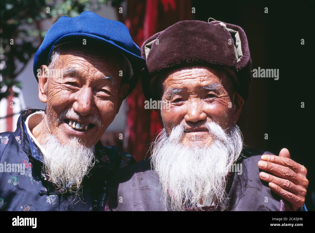 Ritratto di uomini cinesi sorridenti in abiti tradizionali, Yunnan, Cina Foto Stock
