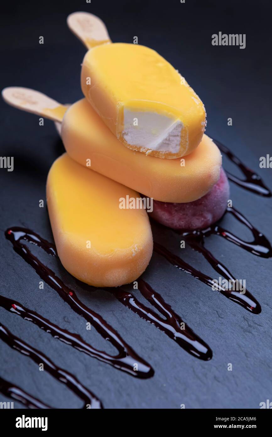Pila di bastone di gelato di frutta sembra fresco da mangiare posto su uno sfondo di pietra nera. Foto Stock