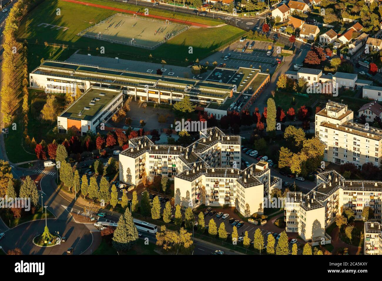 Francia, Yvelines, Les Mureaux, vista aerea al tramonto della città, vista aerea di uno stabilimento scolastico (vista aerea) Foto Stock