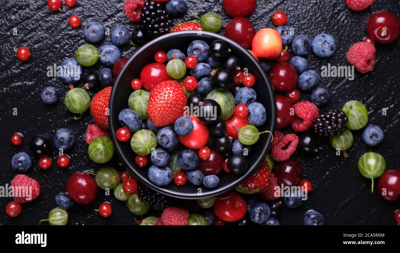 Raccolta di frutti di bosco su sfondo nero, vista dall'alto Foto Stock