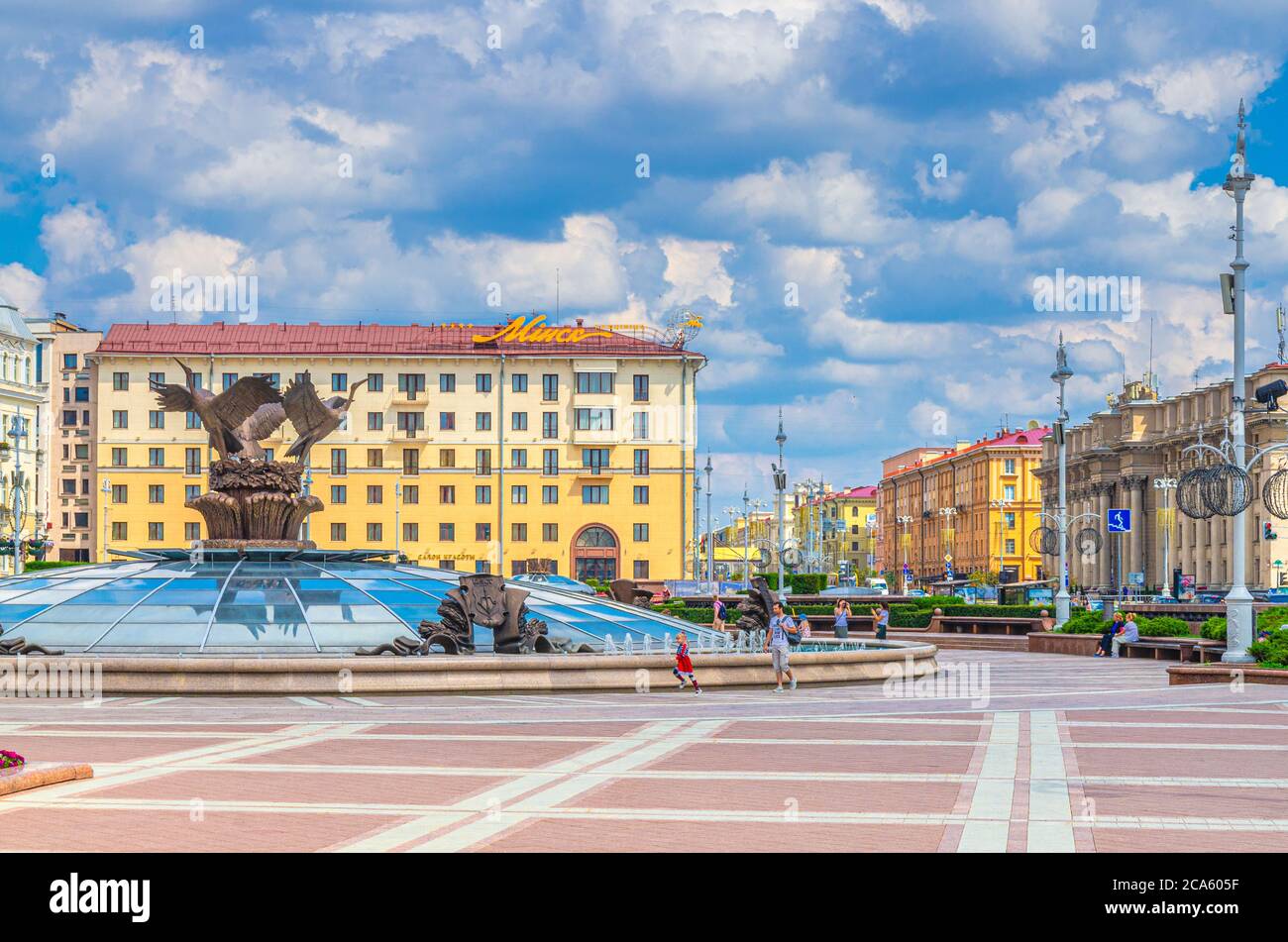 Minsk, Bielorussia, 26 luglio 2020: Piazza dell'indipendenza e viale con il classicismo socialista edifici in stile impero Stalin, Hotel Minsk e persone a piedi, cielo blu nuvole bianche in sole giorno d'estate Foto Stock