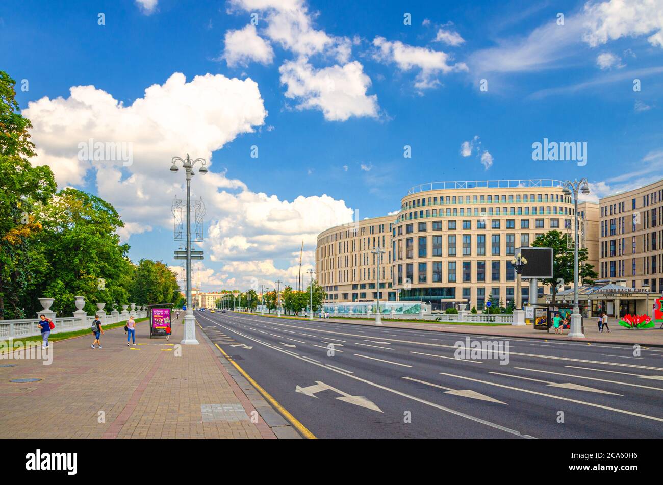 Minsk, Bielorussia, 26 luglio 2020: Independence Avenue con il classicismo socialista edifici in stile Stalin Empire, marciapiede e incompiuto Kempinski hotel, blu cielo bianco nuvole in sole giorno d'estate Foto Stock