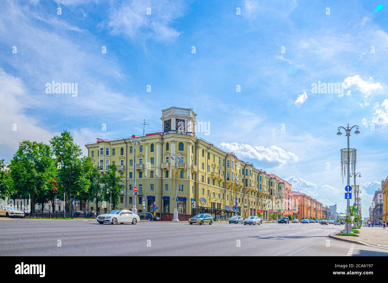 Minsk, Bielorussia, 26 luglio 2020: Independence Avenue con il classicismo socialista edifici in stile Stalin Empire, marciapiede e auto a cavallo e autobus, cielo blu nuvole bianche in estate soleggiato giorno Foto Stock