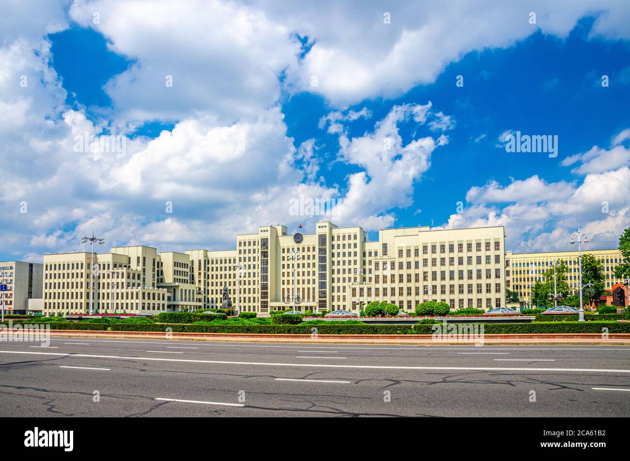 L'edificio in stile costruttivismo della Casa del Governo e la statua di Vladimir Lenin sulla Piazza dell'Indipendenza nel centro storico della città di Minsk, le nuvole bianche del cielo blu nella soleggiata giornata estiva, Repubblica di Bielorussia Foto Stock