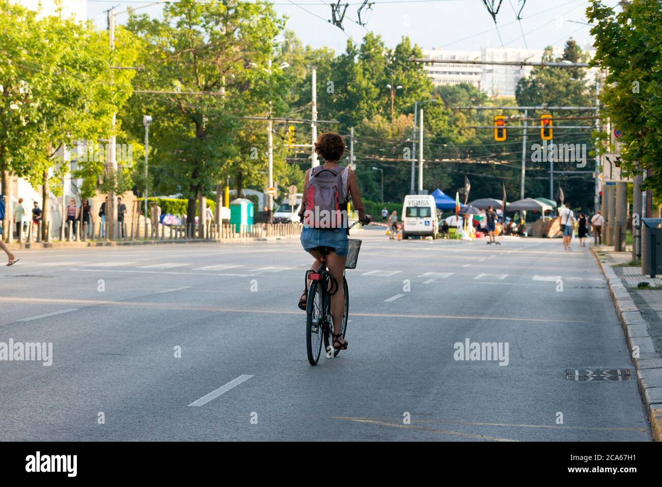 Ciclista solitario, ciclista femminile, Sofia Bulgaria, Europa orientale, Balcani, UE, protesta, protesta pacifica anti-governo, 2020, manifestanti, strada chiusa. strade chiuse. strade vuote, strade vuote, protesta pacifica, protesta, nessun trasporto, chiuso per trasporti, elezioni, elezioni, blocco, blocco, tende per strada, democrazia, Foto Stock