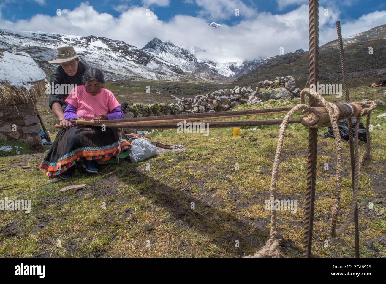 Una donna di quechua nelle alte Ande tesse la lana di alpaca in indumenti, come è stato tradizionalmente fatto per molte generazioni. Foto Stock