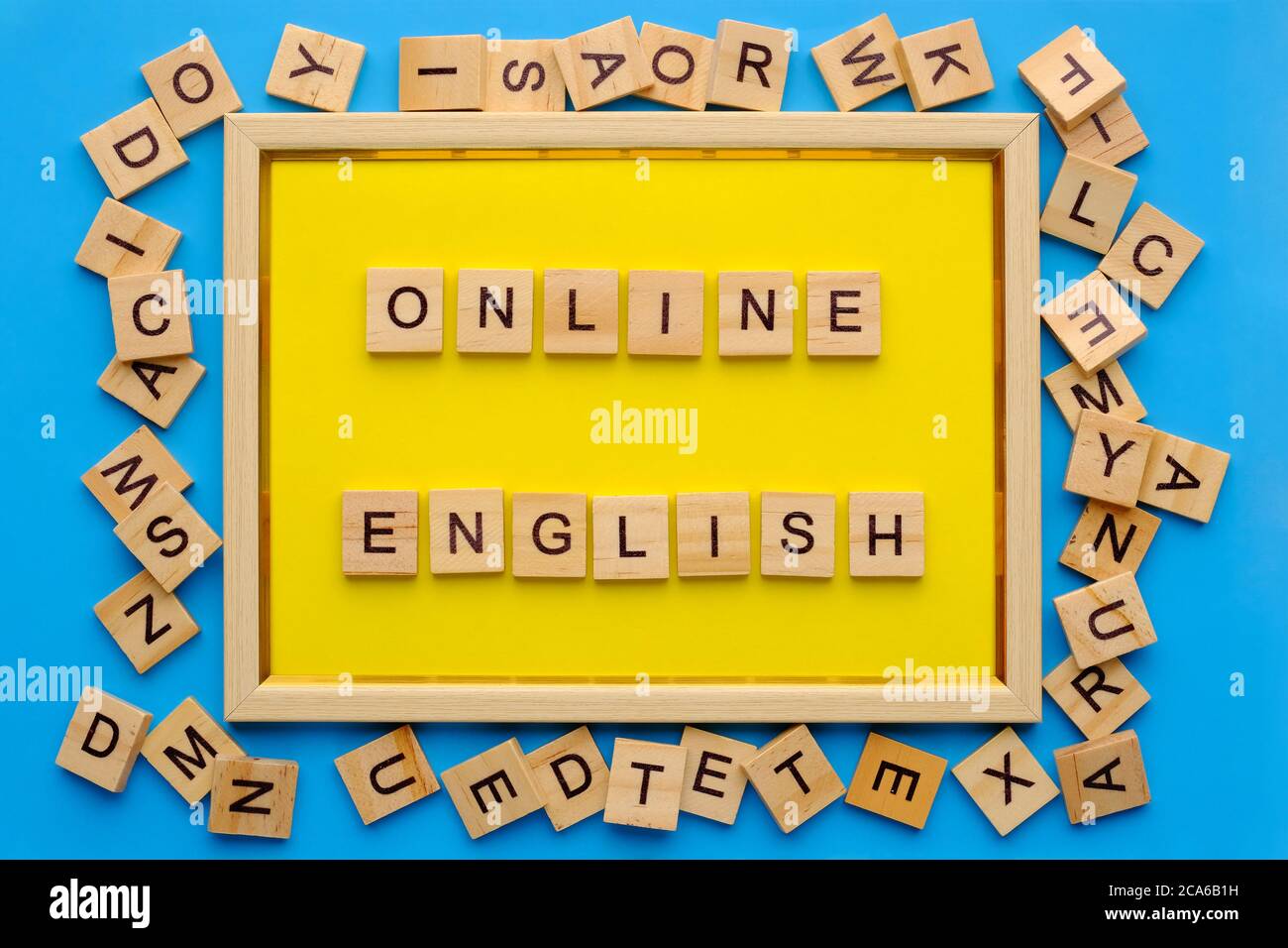 lettere di legno con frase in linea inglese in cornice gialla su sfondo blu. Foto Stock