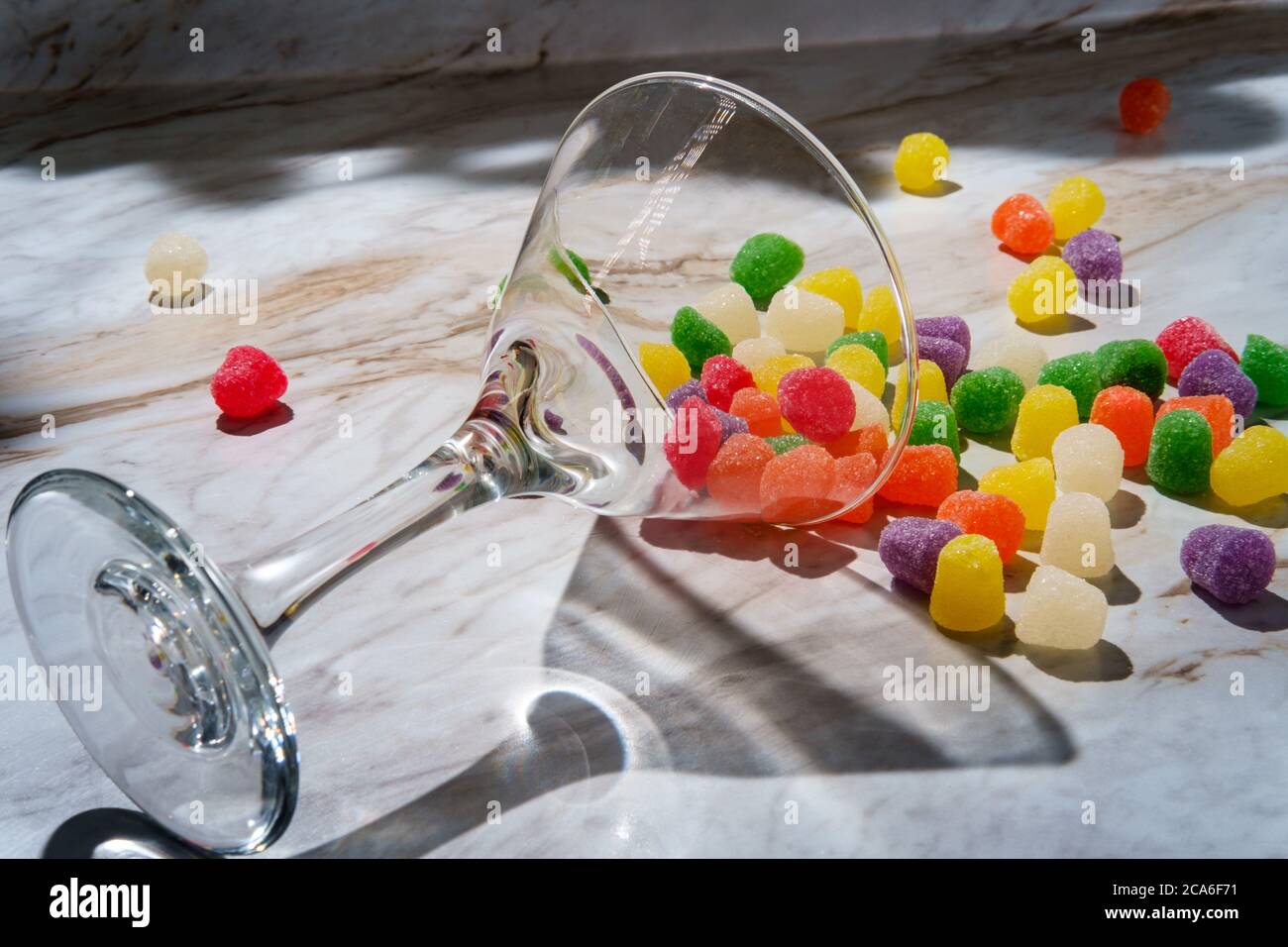 Gocce di caramella ricoperte di zucchero granulato versate in vetro martini Foto Stock