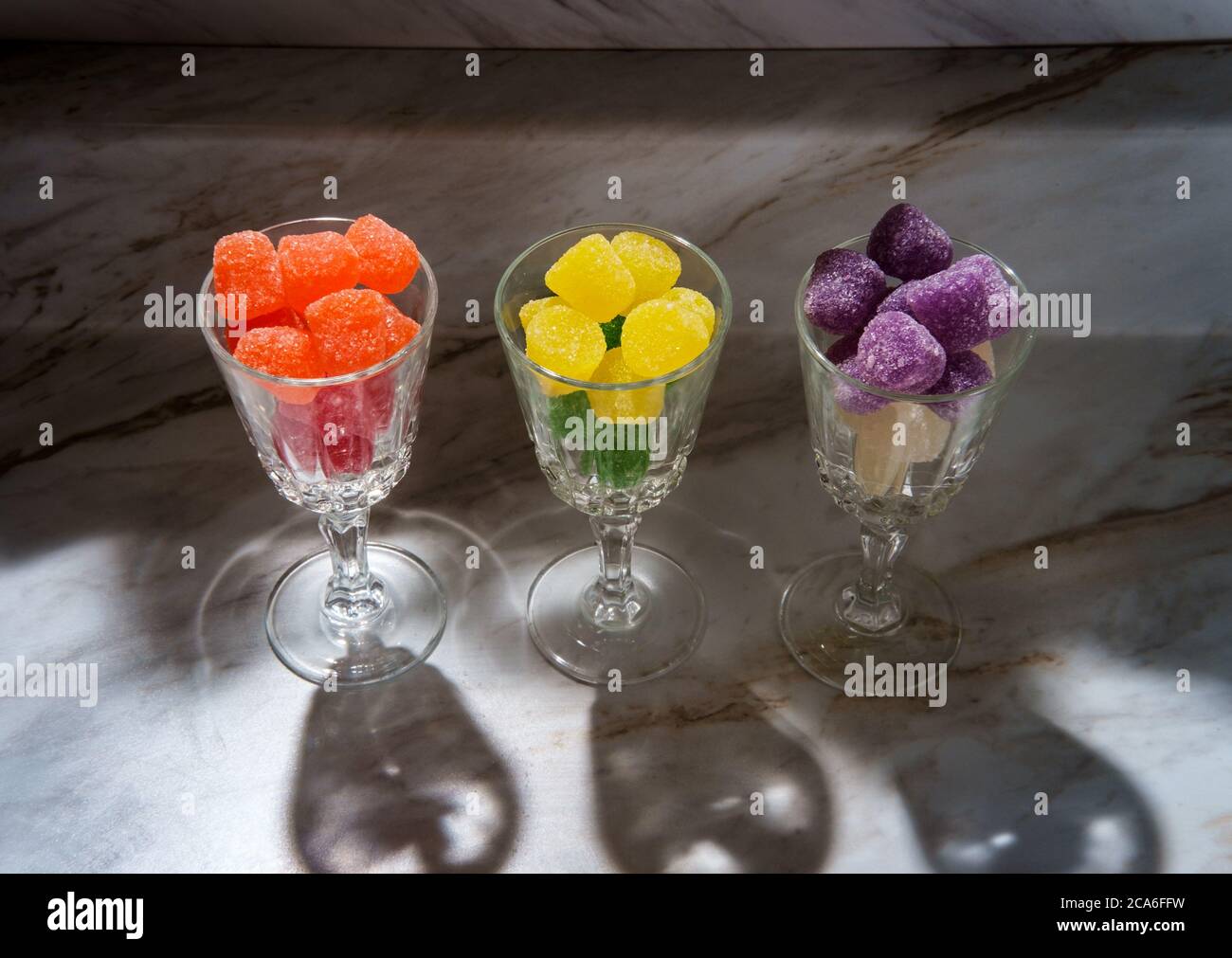 Gocce di caramella ricoperte di zucchero granulato in bicchieri da shot Foto Stock