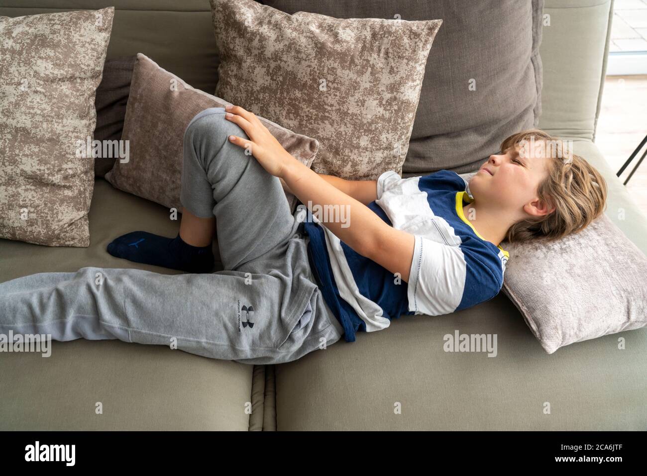 Dolore di crescita nei bambini, ragazzo, 10 anni, ha dolore alla gamba, immagine simbolica, Foto Stock