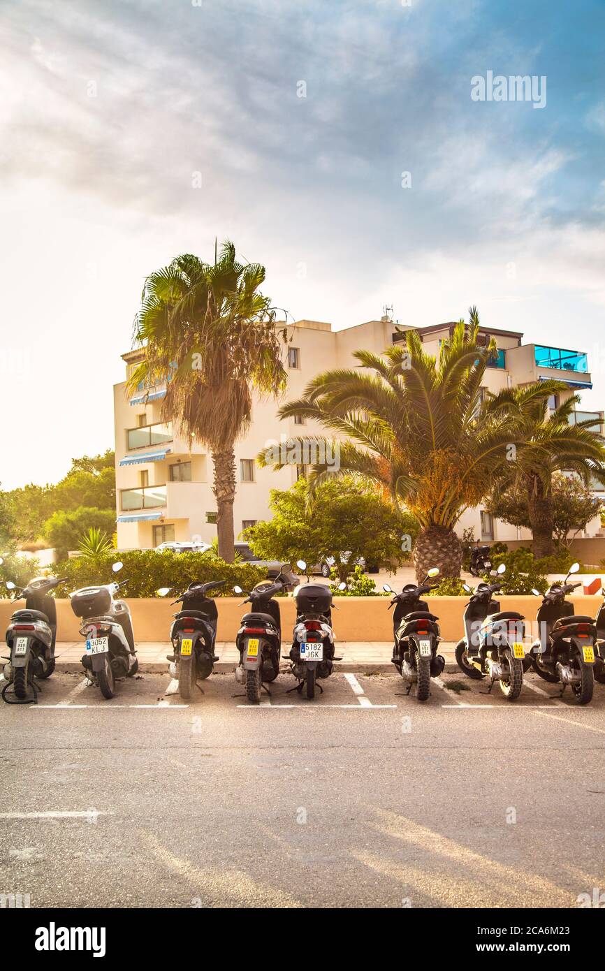Fila di scooter parcheggiati sulla strada a es Pujols, Formentera, Spagna Foto Stock