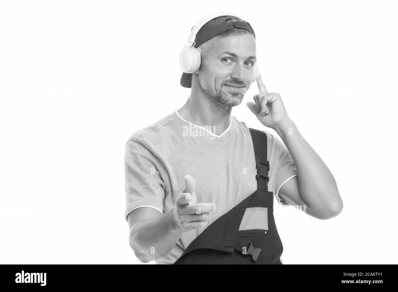 Cuffie che proteggono le orecchie. L'uomo di lavoro indossa le cuffie che puntano il dito. I lavoratori ascoltano la musica con le cuffie. Cuffie wireless. Nuova tecnologia. Musica per il lavoro. Foto Stock