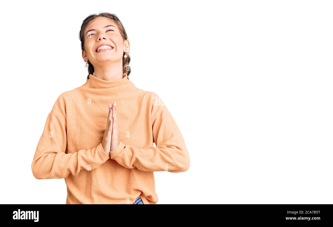 Bella donna caucasica con capelli biondi indossare casual inverno pullover che pregano e pregano con le mani insieme con espressione di speranza sul viso molto emo Foto Stock