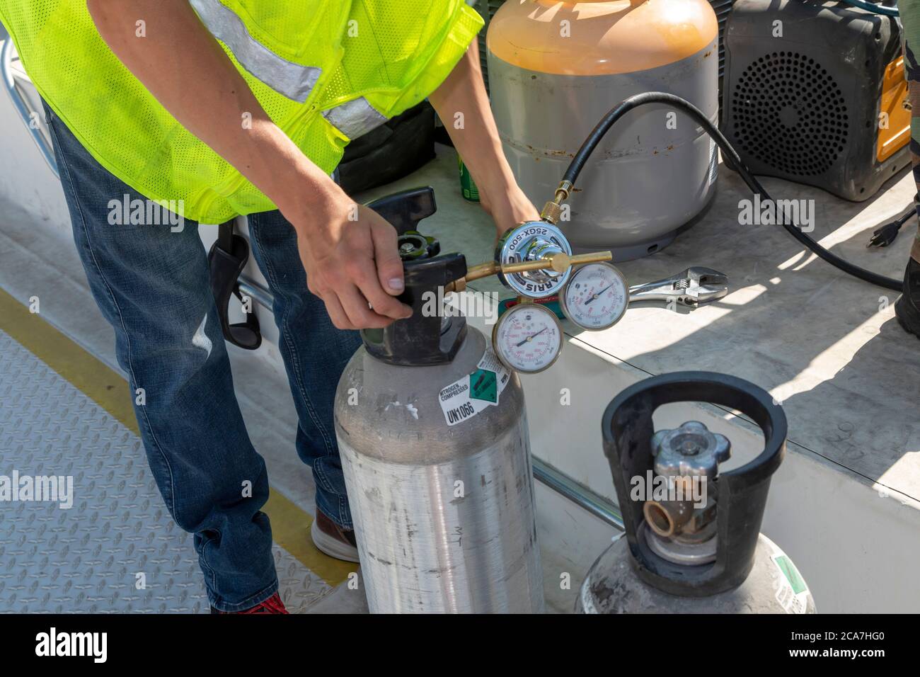 Denver, Colorado - UN tecnico lavora sul sistema di aria condizionata sul tetto di un edificio abitativo accessibile in costruzione. Foto Stock