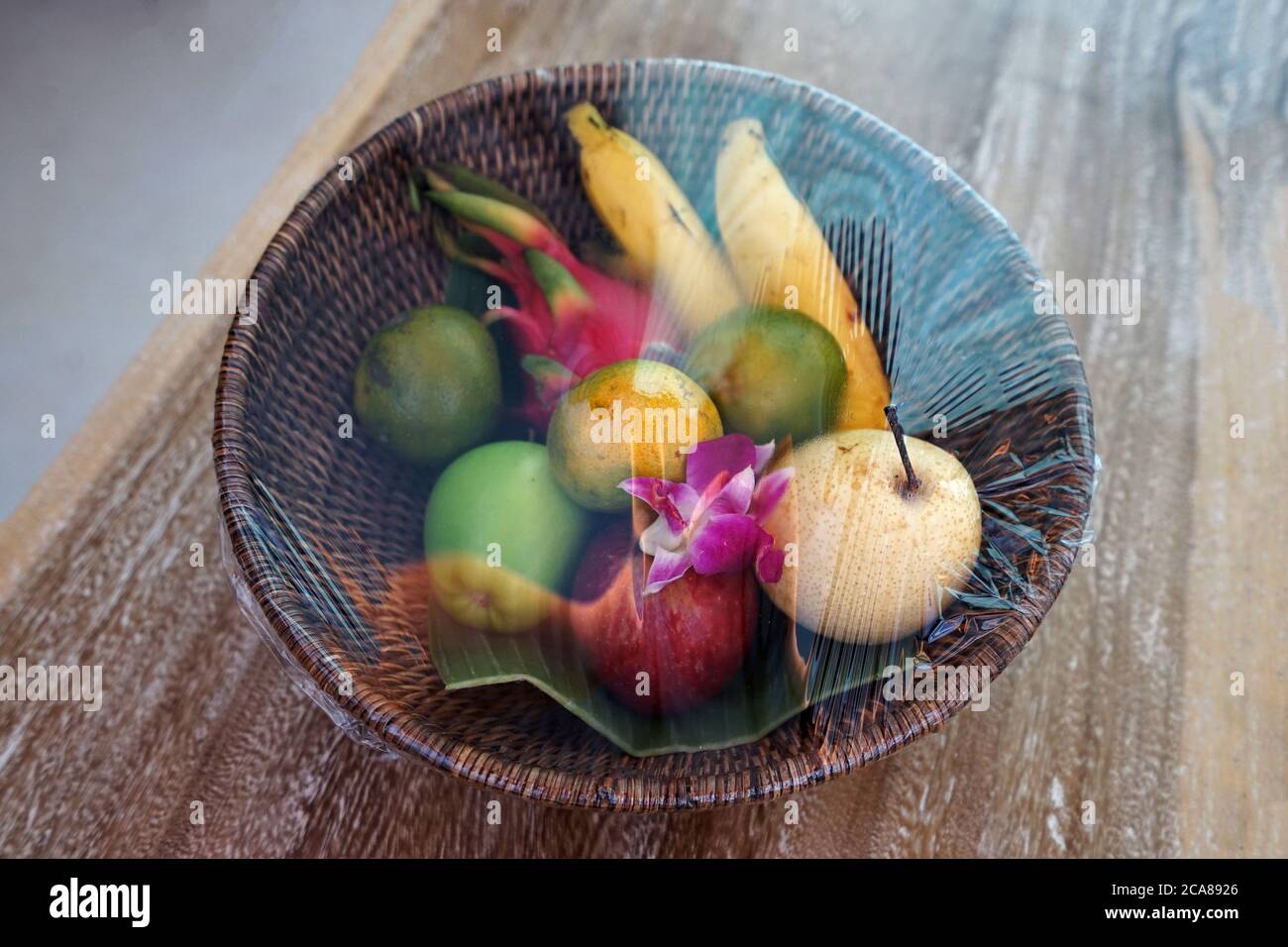 Cestino gratuito di legno di frutta confezionata - contiene banana, arancia, frutta di drago e pera cinese Foto Stock