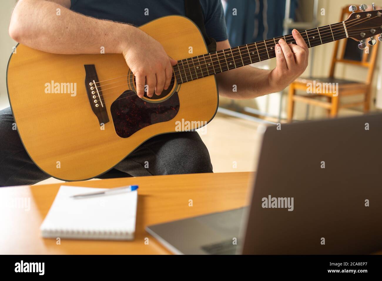 L'uomo impara a suonare la chitarra usando lezioni video online Foto stock  - Alamy